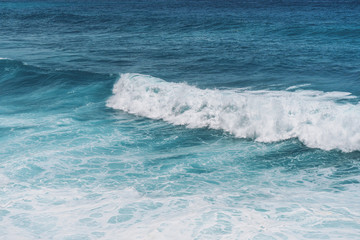 Large blue sea waves with white foam