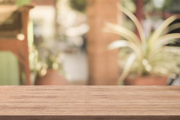 Empty of wood table top with blurred coffee shop on background