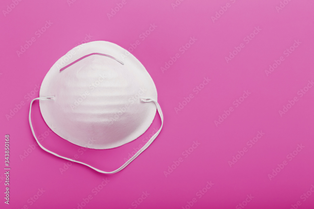 Wall mural Round face mask on a pink background. Isolation of virus protection