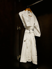 2 White bathing gowns hang in wooden wardrobe