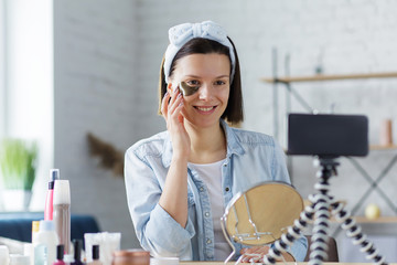 Young female blogger recording a tutorial video for her beauty blog about cosmetics.Vlogger testing...