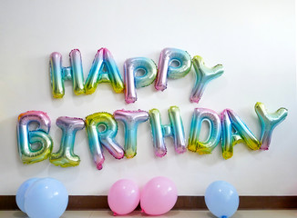 colorful bubble text "HAPPY BIRTH DAY' and blue and pink balloons