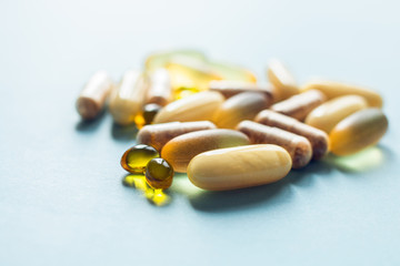 Mixed pills. Pharmaceutical medicine tablets, capsules and pills on the blue background.