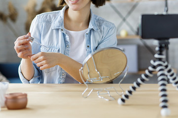Young female blogger recording a tutorial video for her beauty blog about cosmetics.Vlogger testing...