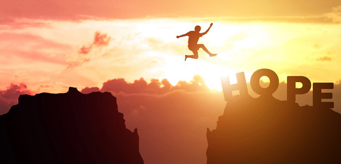 Obraz na płótnie Canvas Silhouette man people jumping from cliff to other mountain with hope, concept as possible and impossible of success in business and leadership. Copy space for label text and banner for advertisement.