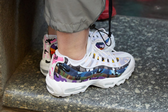 Woman with white Nike sneakers with camouflage fabric on September 21, 2018 in Milan, Italy