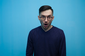 Portrait of an emotional young man in glasses