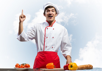 Young male chef standing near cooking table