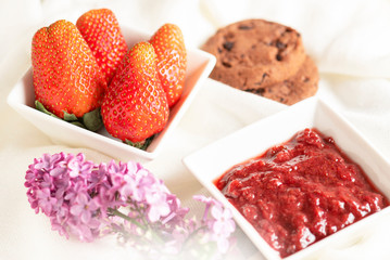 Morning breakfast. Fresh strawberry, strawberry jam and cookies on the white background.