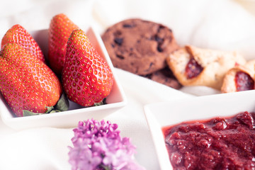 Morning breakfast. Fresh strawberry, strawberry jam and cookies on the white background.