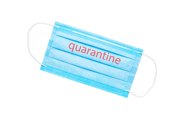 blue medical face mask with the inscription quarantine isolated on a white background. global quarantine concept. flat lay
