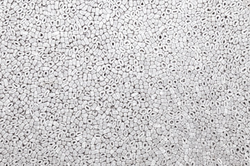 Background of gray color with a pattern of oval and round parts of the styrofoam pressed pressed used for lining or protecting fragile parts close-up. Design panel in a photo studio.