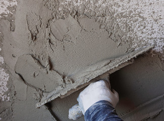 Worker plastering tool plaster marble on interior plaster rough