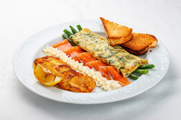 Breakfast. Omelet with salmon and asparagus, baked potatoes and croutons