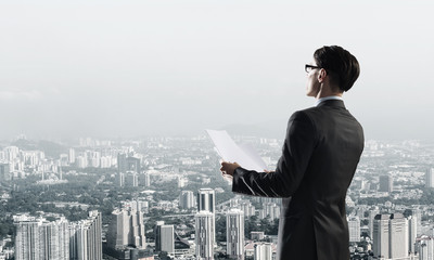Concept of business success and control with confident boss against cityscape background