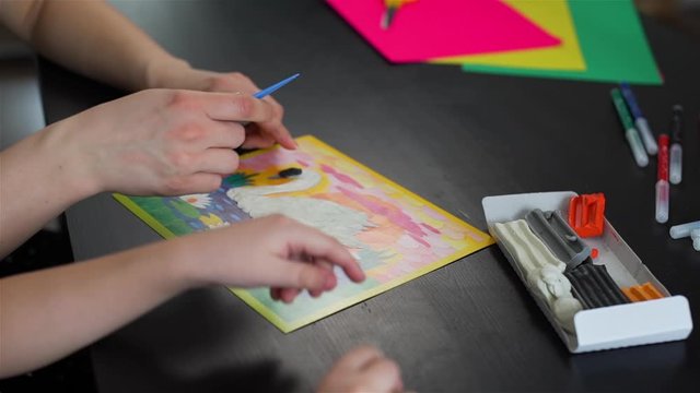 Mother with Little Daughter Crafting with Colorful Plasticine at Home. They Making a Picture of Swan. Concept of Art, Handmade Crafts, Hobby and Activities for Children
