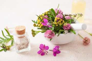 Obraz na płótnie Canvas medical flowers herbs in mortar essential oils in bottles. alternative medicine. clover milfoil tansy rosebay