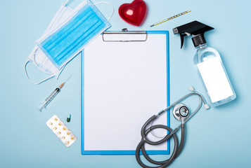 Obraz na płótnie Canvas medical equipment mockup clipboard, stethoscope with red heart and drug, surgical mask on blue copy space background.