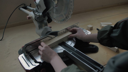 Obraz premium Girl in a workshop sawing wooden materials