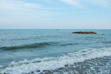 Sea wave breaking into the beach during low tide and high tide..