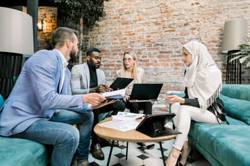 Business conference. Business meeting. Group of young four mixed raced business people in...