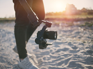 close up videographer holds camera with stabilization gimbal