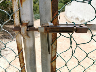 
The iron gate closes the gate with a rusty mesh