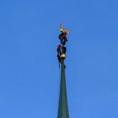 Fototapeta na wymiar Workers fixing golden church spire
