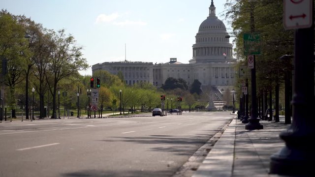 Motion to the left showing US Capitol in distance with empty street mid day.