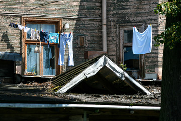 Clothes hanging over an old dilapidated timber building in summer