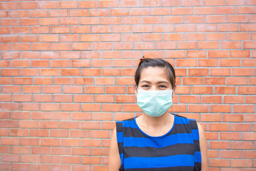 Asian women wearing a mask background brick wall.