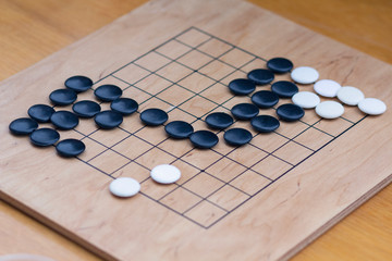 Chinese go game board, close up view of playing black and white stone pieces, Alphago