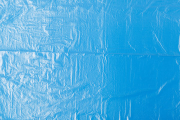 transparent plastic bag on a blue background. The global problem of environmental pollution. Copy space, texture, background