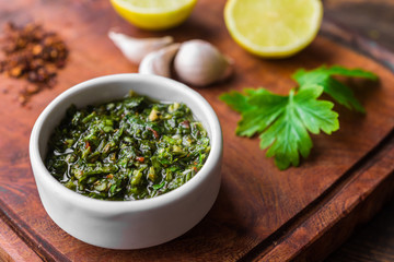Traditional Argentinian chimichurri sauce against wooden backgroundv