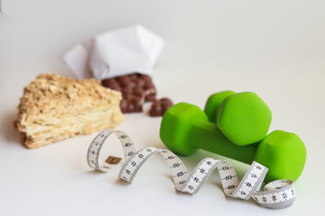 a piece of cake and chocolate bar with a centimeter tape, you need to go on a diet and limit the sweet