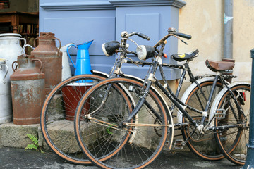Very old rustic vintage bicycles and milk cans