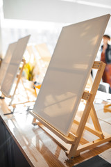 background with easels in art class.  Empty art class with easels and canvases  in the sun