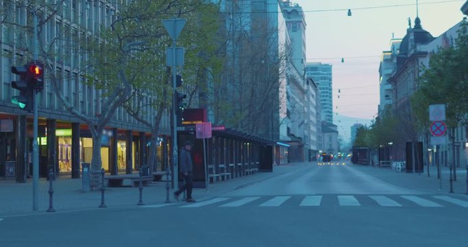 A man crossing the empty street in a downtown�during quarantine