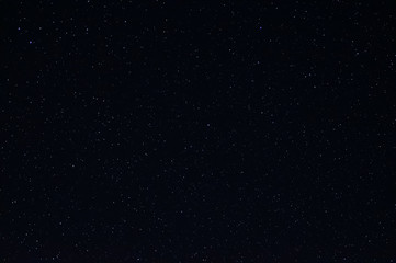 Long exposure night photo of a bright stars. A lot of stars with constellations. Far from the city. Night landscape.