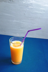 glass of fresh orange juice against blue background with empty space for text, healthy lifestyle concept
