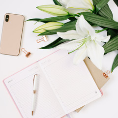 Beautiful fresh white lily and notebook with blank page on white background. Mood blogging concept,...