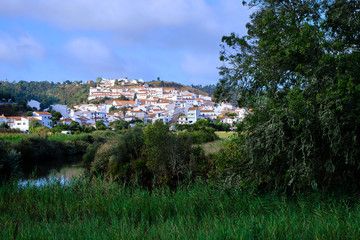 The village of Odeceixe in the morning light. Solo Backpacker Trekking on the Rota Vicentina and Fishermen's Trail in Algarve, Portugal. Walking between cliff, ocean, nature and beach.