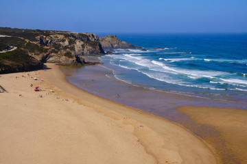 Praia de Odeceixe. Solo Backpacker Trekking on the Rota Vicentina and Fishermen's Trail in Algarve, Portugal. Walking between cliff, ocean, nature and beach.
