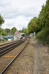 Fototapeta na wymiar Small railroad station with only two platforms and rail tracks.