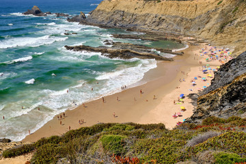 Beach and cliff at Praia da Zambujeira do Mar. Solo Backpacker Trekking on the Rota Vicentina and Fishermen's Trail in Alentejo, Portugal. Walking between cliff, ocean, nature and beach.