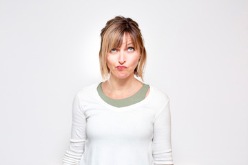 Mujer pensativa en fondo blanco mirando arriba