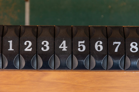 A black number slider on a table of the game of foosboll (fusbol) top view. Number sequence concept.