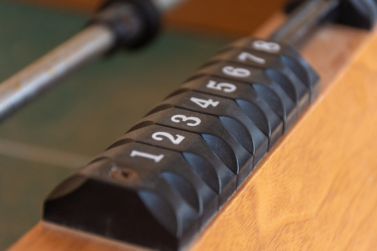 A black number slider on a table of the game of foosball (fusbol). Number sequence concept.