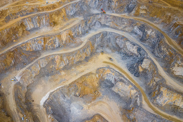 Mining from above. Industrial terraces on open pit  mineral mine. Aerial view of opencast mining. Dolomite Mine Excavation. Extractive industry. Giant excavator machinery.