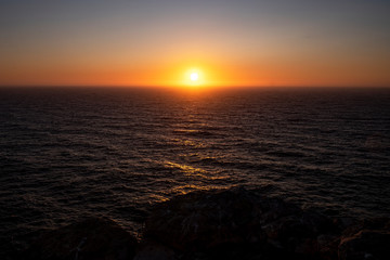 Sunset at Cliff at Cabo de Sao Vincente. Solo Backpacker Trekking on the Rota Vicentina and Fishermen's Trail in Algarve, Portugal. Walking between  ocean, nature and beach.